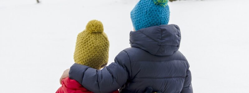 Veljekset katsovat talvista maisemaa villapipot päässä.