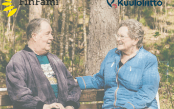 Kuvassa mies ja nainen katsovat toisiinsa kesäisessä maisemassa. Ylhäällä FinFamin ja Kuuloliiton logot