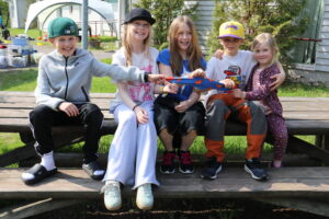 Kuvassa 5 iloista leiriläistä ryhmäkuvassa