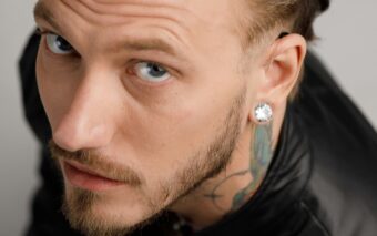 mies katsoo kameraan, korvassa korvis.